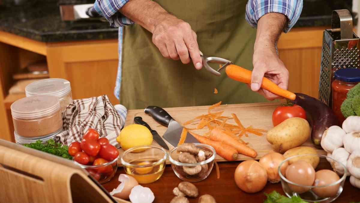 mid section unrecognizable cook preparing ingredients dinner dish scraping carrots