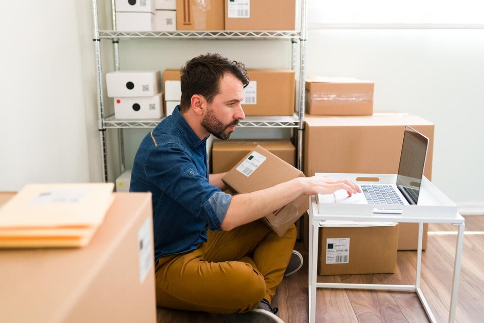 hispanic young man sitting his office floor while holding package typing laptop check customer order from online shop 662251 2205