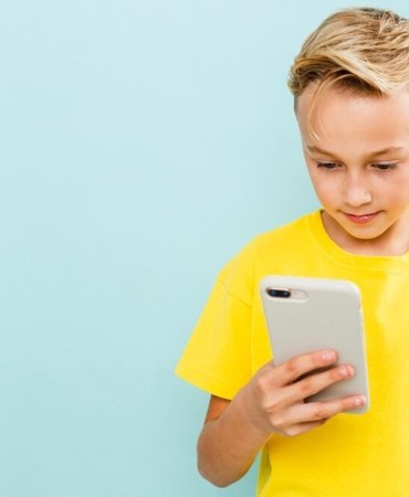 front-view-boy-using-phone-with-copy-space_23-2148356661