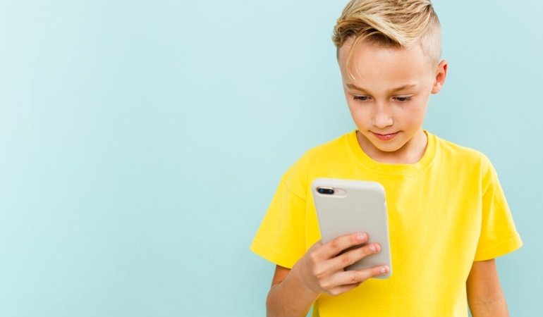 front-view-boy-using-phone-with-copy-space_23-2148356661