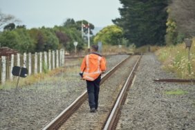 railroad-worker-walking-away-rail-tracks_181624-51784