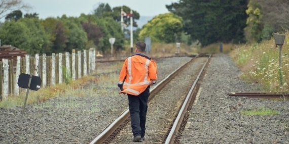 railroad-worker-walking-away-rail-tracks_181624-51784