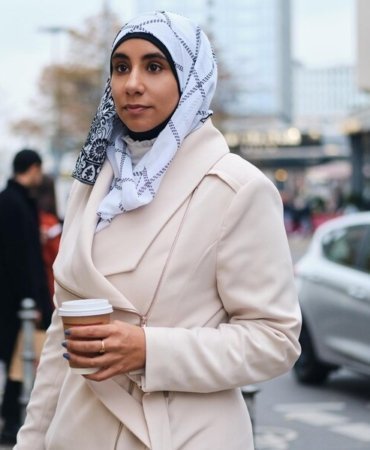 young-attractive-arabic-woman-hijab-dreamily-walking-around-city-street-with-coffee-go_574295-2983