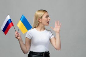 ukraine-russian-conflict-blonde-cute-girl-holding-russian-ukrainian-flag-yelling-someone
